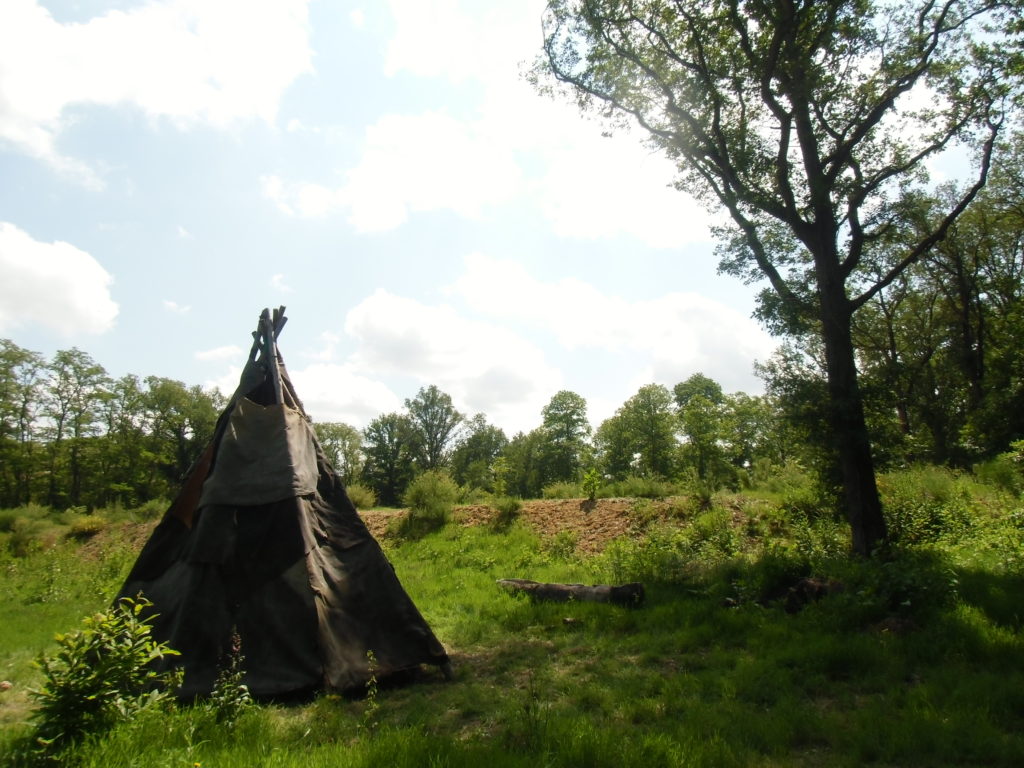 Tipi du paléolithique final. Au second plan : talus séparant la forêt de la steppe glaciaire. Crédits : Nicolas Patissier pour Studio Zef